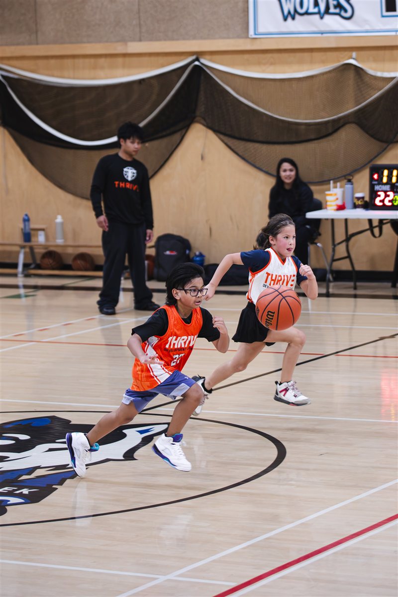 Basketball players competing for possession at centre court