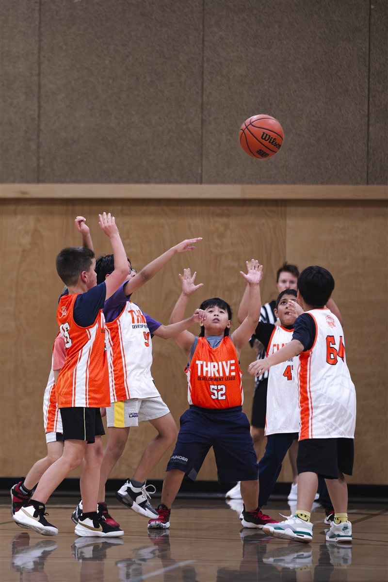 Players reaching for a basketball during a game
